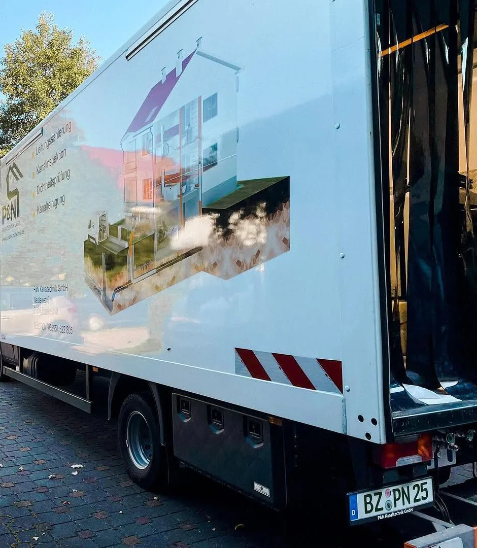 Sanierungs-Lkw des Partnerbetriebs in einer Hofeinfahrt